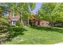 Beautiful brick home with a well-maintained lawn, mature trees, and inviting curb appeal at 14215 Stacey St, Carmel, IN 46033