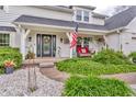 Charming front porch with cozy seating, decorative wreaths, and lush landscaping creating a welcoming entrance at 14809 Senator Way, Carmel, IN 46032