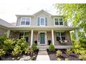 Inviting front porch with a swing, brick columns, and a decorated front door wreath at 16579 Lakeville Xing, Westfield, IN 46074