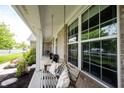 Relaxing front porch with a swing and decorative pillows, showcasing outdoor living space at 16579 Lakeville Xing, Westfield, IN 46074