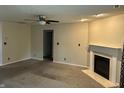 Open living room featuring neutral paint, plush carpet, a fireplace, and a ceiling fan at 1716 W Witt Ave, Lebanon, IN 46052