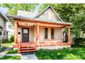 Charming home featuring a covered porch with orange columns and freshly painted trim accents at 2114 Sugar Grove Ave, Indianapolis, IN 46202