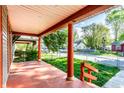 Inviting covered front porch with orange painted floor and columns, perfect for outdoor relaxation at 2114 Sugar Grove Ave, Indianapolis, IN 46202