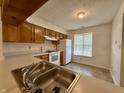 Well-lit kitchen with wood cabinets, white appliances, and a bright window view at 212 Woodberry Dr, Danville, IN 46122