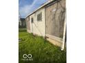 Side view of a boarded up house with siding and lawn at 2534 Carrollton Ave, Indianapolis, IN 46205