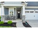 Inviting front porch with stone pillars and cozy seating area, perfect for relaxing and enjoying the outdoors at 2675 Cottage Ct, Brownsburg, IN 46112