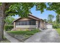 Charming single-story home with a brick facade and a long driveway leading to a detached garage at 309 Poplar Rd, Indianapolis, IN 46219