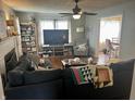 Cozy living room with a large sectional sofa, a ceiling fan, and an adjacent dining area at 310 S Butler Ave, Indianapolis, IN 46219
