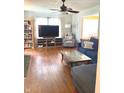 Bright living room with hardwood floors, ceiling fan, bookshelves, and large window at 310 S Butler Ave, Indianapolis, IN 46219