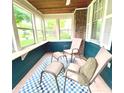 Enclosed porch with beautiful windows and cozy seating on a blue and white rug at 310 S Butler Ave, Indianapolis, IN 46219