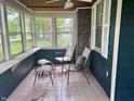 Enclosed sunroom featuring tiled floor, multiple windows, and comfortable seating at 310 S Butler Ave, Indianapolis, IN 46219