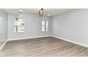 Spacious bedroom with wood-look floors, neutral walls, two windows and a modern light fixture at 3241 Ruckle St, Indianapolis, IN 46205