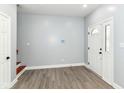 Light-filled entryway with modern gray walls, wood-look floors, and a white door with decorative glass at 3241 Ruckle St, Indianapolis, IN 46205