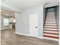 Open-concept living space features gray walls, wood floors, a staircase and flows into the kitchen at 3241 Ruckle St, Indianapolis, IN 46205