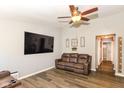 Spacious living area featuring wood-look floors, a large TV, and comfortable seating with cupholders at 3608 Valley Lake Dr, Indianapolis, IN 46227
