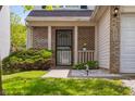 Close up of front porch with brick facade, black iron security door, and flower pot at 3937 Candle Berry Dr, Indianapolis, IN 46235