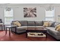 Comfortable living room with a large gray sectional, a tree art piece and lots of light at 3937 Candle Berry Dr, Indianapolis, IN 46235