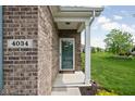 Inviting entryway featuring a glass-paneled front door, welcome mat, and a clear view of the lush front yard at 4034 Cairo Way, Avon, IN 46123