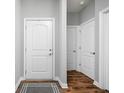 Bright hallway with wood flooring, white doors, and neutral walls providing access to various rooms at 4034 Cairo Way, Avon, IN 46123