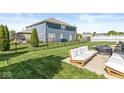 Spacious, fenced backyard featuring lush lawn, patio furniture, and ample room for outdoor activities at 5622 Hare Dr, Noblesville, IN 46062