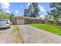 A single-story brick home with a driveway, lawn, and mature trees at 6191 Geneva St, Stilesville, IN 46180
