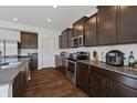 Stylish kitchen featuring dark cabinetry, stainless steel appliances, granite countertops, and wood flooring at 6903 Aster Dr, Pendleton, IN 46064