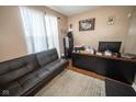 Bright home office features a comfortable sofa, a desk, a filing cabinet, and hardwood flooring at 6913 Thousand Oaks Ln, Indianapolis, IN 46214
