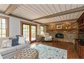 Cozy living room with a brick fireplace, beamed ceiling, and access to a deck through glass doors at 7189 Creekwood Estates, Brownsburg, IN 46112