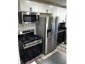 Well-equipped kitchen with stainless steel appliances, white cabinets, and a black countertop, ready for culinary adventures at 7334 Westchester Dr, Indianapolis, IN 46226