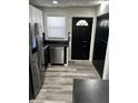Modern kitchen featuring stainless steel appliances, sleek black cabinets, and stylish wood-look flooring at 7334 Westchester Dr, Indianapolis, IN 46226