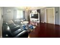 Spacious living room featuring modern furniture, hardwood floors, and a large window at 7764 Hollybrook Ln, Southport, IN 46227