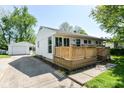 View of home and detached garage with driveway; home features a light wooden porch at 7849 E 49Th St, Indianapolis, IN 46226