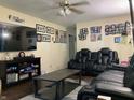 Comfortable living room with plush leather seating, a ceiling fan, and entertainment center at 8410 Woodlawn Dr, Martinsville, IN 46151