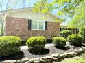 Charming brick home with well-maintained landscaping, featuring mulch beds and stone edging at 8835 Briarclift Rd, Indianapolis, IN 46256