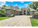Gorgeous home with a paved circular driveway, a stone entryway, and lush landscaping at 8905 Stonebriar Dr, Indianapolis, IN 46259