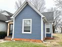 Picture showcasing the side of a single-Gathering home, with well-maintained lawn and light blue siding at 929 W Roache St, Indianapolis, IN 46208