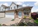 Attractive townhome with brick accents, a white front door, and professionally landscaped garden at 9404 Enclave Dr # D, Avon, IN 46123
