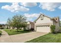 Inviting home showcasing a well-manicured lawn and a two-car garage with brick detailing at 9760 Innisbrook Blvd, Carmel, IN 46032