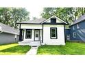 Charming bungalow with black and white trim, featuring a small front porch and walkway to the home at 1148 N Pershing Ave, Indianapolis, IN 46222