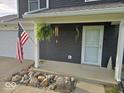 Front porch with well-kept landscaping and an American flag at 1214 Lindsey Ln, Lebanon, IN 46052