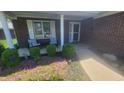Inviting porch with seating area, lush landscaping, and charming brick facade at 123 Old Farm Rd, Danville, IN 46122