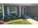 Inviting front porch with seating, lush landscaping, and a charming brick facade at 123 Old Farm Rd, Danville, IN 46122