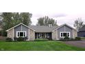 Beautiful single-story home with stone accents, gray siding, a well-manicured lawn and charming curb appeal at 12681 E 79Th St, Indianapolis, IN 46236