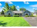 Charming single-story home boasts stone and gray siding, complemented by lush landscaping at 12681 E 79Th St, Indianapolis, IN 46236