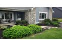 Inviting front porch with stone accents, a porch swing, cozy seating, and beautiful landscaping at 12681 E 79Th St, Indianapolis, IN 46236