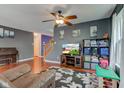 The living room has hardwood floors, a ceiling fan, a TV, and comfortable seating arrangements at 13295 Patriotic Way, Fishers, IN 46037