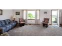 Cozy living room with carpet, comfortable seating, a large window, and an exterior door at 133 W Us Highway 52, Fountaintown, IN 46130