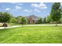 Expansive lawn surrounds this stunning brick home, showcasing its architectural details and landscaping at 13309 Carmichael Ln, Carmel, IN 46074