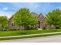 Inviting brick home with lush greenery and mature trees at 13309 Carmichael Ln, Carmel, IN 46074