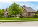 Charming brick home with well-kept lawn and trimmed hedges at 13309 Carmichael Ln, Carmel, IN 46074